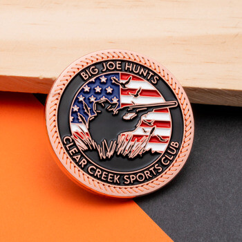 Circular challenge coin with copper rope edge, featuring a hunter silhouette against an American flag background with Big Joe Hunts text.