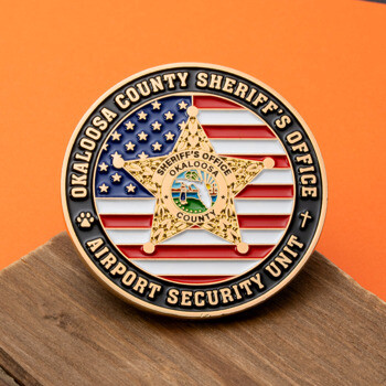 Okaloosa County Sheriff's Office Airport Security Unit challenge coin featuring a gold star over an American flag background.