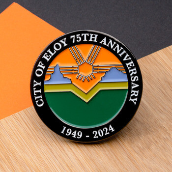 Enamel lapel pin for the City of Eloy 75th Anniversary featuring a landscape design with mountains and a sun emblem.