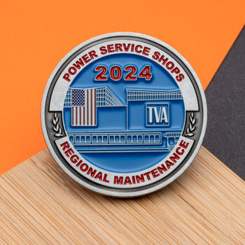 Circular challenge coin for TVA Power Service Shops 2024 featuring a building illustration and American flag on a blue background.