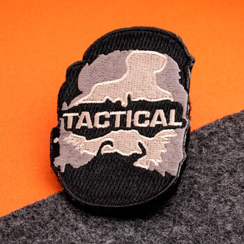 Tactical embroidered patch featuring a camouflage design and bold lettering on a black border.
