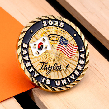 Gold challenge coin featuring South Korean and US flags, rope edge, and text reading Safety is Universal Taylor 1 2025.