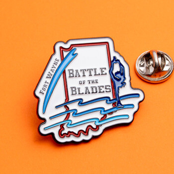 Fort Wayne Battle of the Blades enamel lapel pin shaped like the state of Indiana with clutch backing on an orange background.